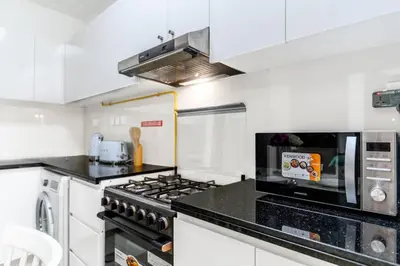 a kitchen with a stove and a microwave at FAM Living 1BR Stay Binghatti Gateway, Al Jaddaf in Dubai