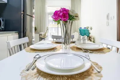 a dining room table with plates and flowers on it at FAM Living 1BR Stay Binghatti Gateway, Al Jaddaf in Dubai