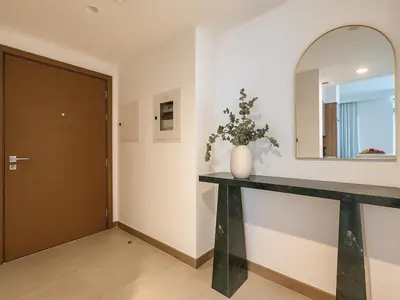 a hallway with a console table and a mirror at Luxury Studio in Urban Oasis, Business Bay in Dubai