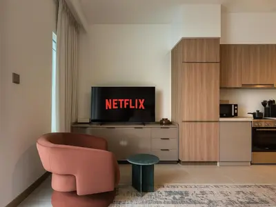 a living room with a chair and a television at Luxury Studio in Urban Oasis, Business Bay in Dubai