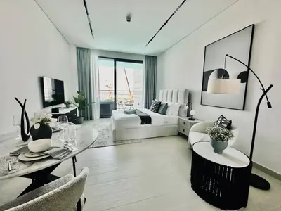 a large white room with a bed and a table at Serene Canalfront Studio Apt With Private Jacuzzi! in Dubai