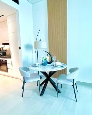 a dining room table with two chairs and a table with a lamp at Serene Canalfront Studio Apt With Private Jacuzzi! in Dubai