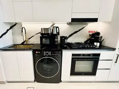 a kitchen with a stove and a washing machine at Serene Canalfront Studio Apt With Private Jacuzzi! in Dubai