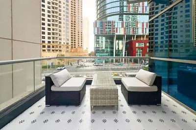 a balcony with two chairs and a table on a building at Stylish Studio with Spacious Balcony Walk to JBR Beach in Dubai