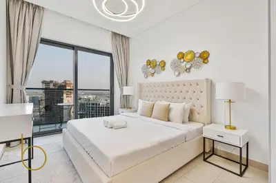 a white bedroom with a large bed and a window at Bookable - 2 Bedroom Sobha Waves, Sobha Hartland in Dubai