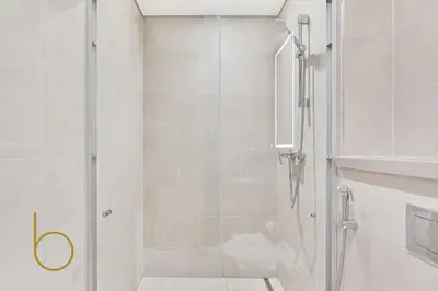 a shower with a glass door in a bathroom at Bookable - 2 Bedroom Sobha Waves, Sobha Hartland in Dubai
