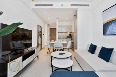 a living room with a white couch and a table at Bookable - 2 Bedroom Sobha Waves, Sobha Hartland in Dubai