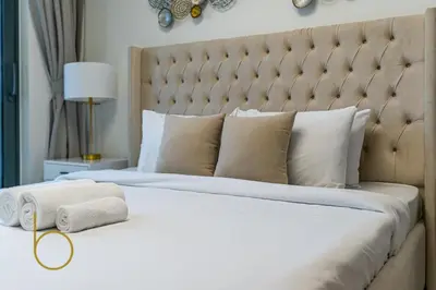 a bedroom with a large bed with a large headboard at Bookable - 2 Bedroom Sobha Waves, Sobha Hartland in Dubai