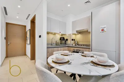 a dining room with a white table and chairs at Bookable - 2 Bedroom Sobha Waves, Sobha Hartland in Dubai