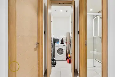 a hallway with a washing machine in a room at Bookable - 2 Bedroom Sobha Waves, Sobha Hartland in Dubai