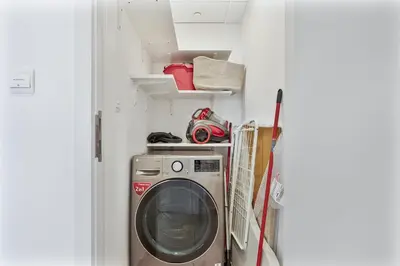 a washer and dryer in a small room at Serene 1BR Stay with Pool, Gym, & Kids Playground in Dubai