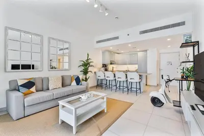a living room with a couch and a table at Serene 1BR Stay with Pool, Gym, & Kids Playground in Dubai
