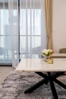 a coffee table in a living room with a large window at Waves - Impressive 1BR Apartment Close to Burj Khalifa in Dubai