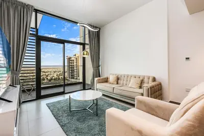 a living room with a couch and a table at Luxury 1BR Hills Green View Mall & Downtown Dining Shopping in Dubai