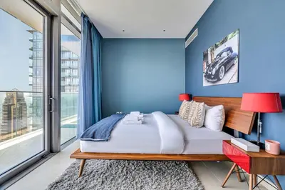 a blue bedroom with a large bed and a desk at DAYF-MGA Spacious 3Bed with Full Marina View in Dubai