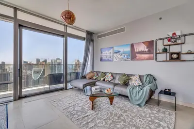 a living room with a couch and a large window at DAYF-MGA Spacious 3Bed with Full Marina View in Dubai