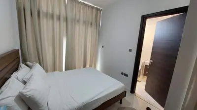 a bedroom with a white bed and a window at Damac hills 2 vardon cluster in Dubai