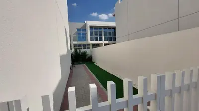 a white fence in front of a building at Damac hills 2 vardon cluster in Dubai