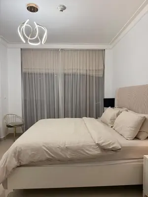 a bedroom with a large white bed with a chandelier at 3403!Dubai SkyLine View! Royal Montania Homes in Dubai