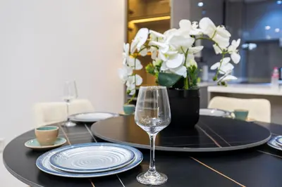 a table with a glass of wine on a table at Modern 1BR with High Floor Near Mall & Tram in Dubai