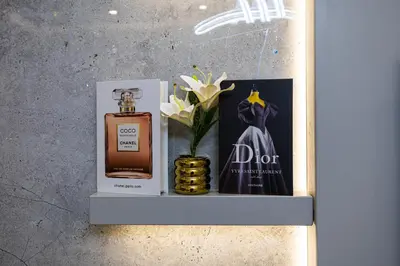 a bottle of perfume and a book on a shelf at Modern 1BR with High Floor Near Mall & Tram in Dubai