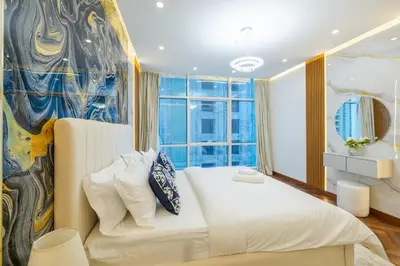 a bedroom with a white bed and a large window at Modern 1BR with High Floor Near Mall & Tram in Dubai