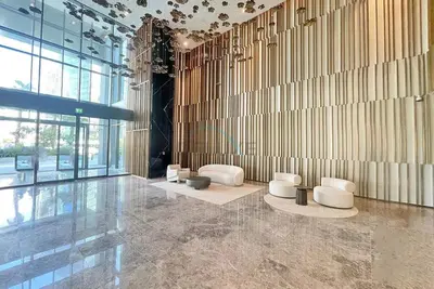 a lobby with white chairs and a wall of windows at Furnished 1BR, Walk to Business Bay Metro, Near Downtown, Ahad Residences, Business Bay by Deluxe Holiday Homes in Dubai