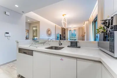 a kitchen with white cabinets and a sink at Furnished 1BR, Walk to Business Bay Metro, Near Downtown, Ahad Residences, Business Bay by Deluxe Holiday Homes in Dubai