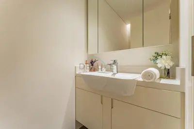a white bathroom with a sink and a mirror at Furnished 1BR, Walk to Business Bay Metro, Near Downtown, Ahad Residences, Business Bay by Deluxe Holiday Homes in Dubai