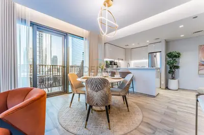 a dining room and living room with a table and chairs at Furnished 1BR, Walk to Business Bay Metro, Near Downtown, Ahad Residences, Business Bay by Deluxe Holiday Homes in Dubai
