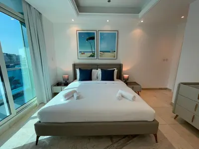 a bedroom with a large bed and large windows at Bright 1BR with Marina Views - Orra Marina - Allsopp & Allsopp in Dubai