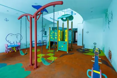 a play room with a playground with swings at Bright 1BR with Marina Views - Orra Marina - Allsopp & Allsopp in Dubai