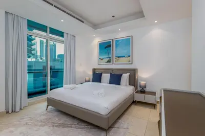 a bedroom with a bed and a large window at Bright 1BR with Marina Views - Orra Marina - Allsopp & Allsopp in Dubai
