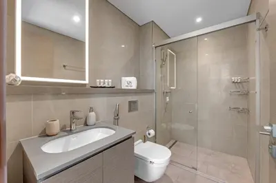 a bathroom with a toilet and a sink and a shower at Relaxing 1BR w Maids room Minutes to Dubai Mall by Vibel in Dubai