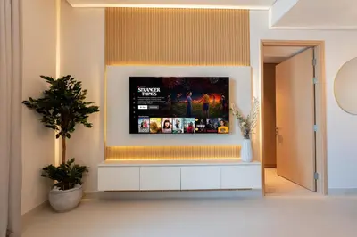 a living room with a tv on the wall at Luxurious 1BR Dubai Mall Burj Khalifa View pool in Dubai