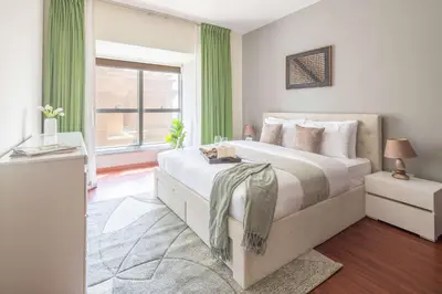 a bedroom with a large bed with green curtains at Frank Porter - B324 - 5112 Elite Residence in Dubai