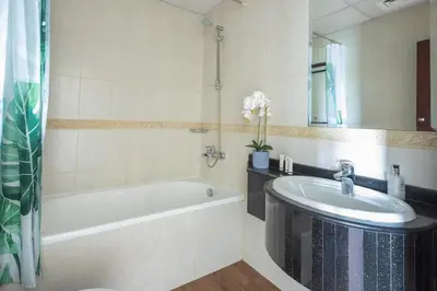 a bathroom with a tub and a sink and a mirror at Frank Porter - B324 - 5112 Elite Residence in Dubai