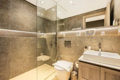 a bathroom with a shower and a toilet and a sink at Stylish Studio Near Miracle Garden - Luxury Amenities & Style in Dubai