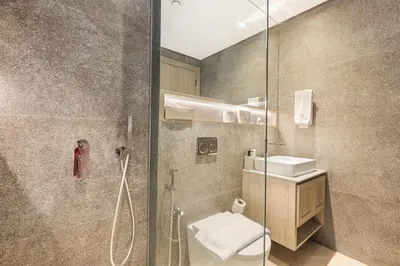 a bathroom with a shower and a toilet and a sink at Stylish Studio Near Miracle Garden - Luxury Amenities & Style in Dubai