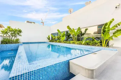 a swimming pool in a villa with a blue tiled swimming pool at Stylish Studio Near Miracle Garden - Luxury Amenities & Style in Dubai
