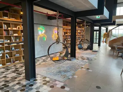 a library with two swings in the middle of a room at FIRST CLASS 1BR Modern Majesty in Dubai Hills in Dubai