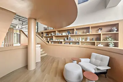a living room with a white chair and a staircase at FIRST CLASS 1BR Modern Majesty in Dubai Hills in Dubai