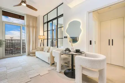 a living room with a couch and a table and chairs at FIRST CLASS 1BR Modern Majesty in Dubai Hills in Dubai