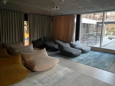 a living room with couches and a large window at FIRST CLASS 1BR Modern Majesty in Dubai Hills in Dubai