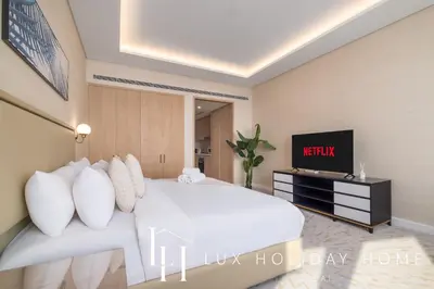 a bedroom with a white bed and a tv at LUX Iconic Views at The Palm Tower Studio 3 in Dubai