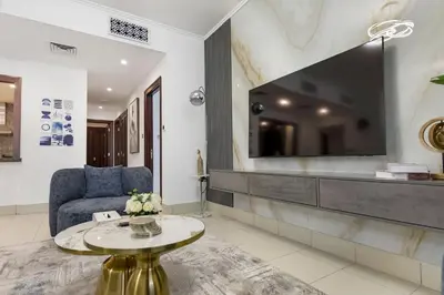 a living room with a tv and a couch and a table at Durrani Homes - Zaafaran Luxe Stay Iconic Burj View in Dubai