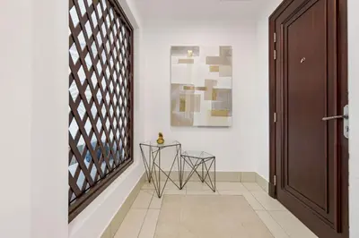 a hallway with a table and chairs next to a door at Durrani Homes - Zaafaran Luxe Stay Iconic Burj View in Dubai