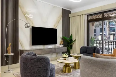 a living room with a tv on a wall at Durrani Homes - Zaafaran Luxe Stay Iconic Burj View in Dubai