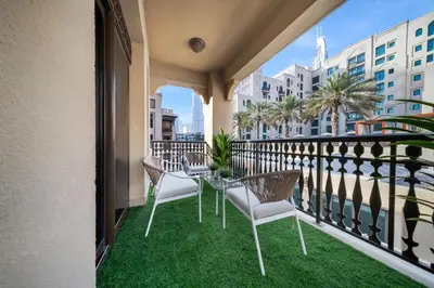 a balcony with chairs and a table with grass at Durrani Homes - Zaafaran Luxe Stay Iconic Burj View in Dubai