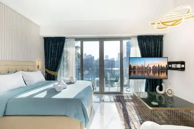 a bedroom with a bed and a tv on a wall at FIRST CLASS Studio Downtown Bliss Urban Gem in Dubai
